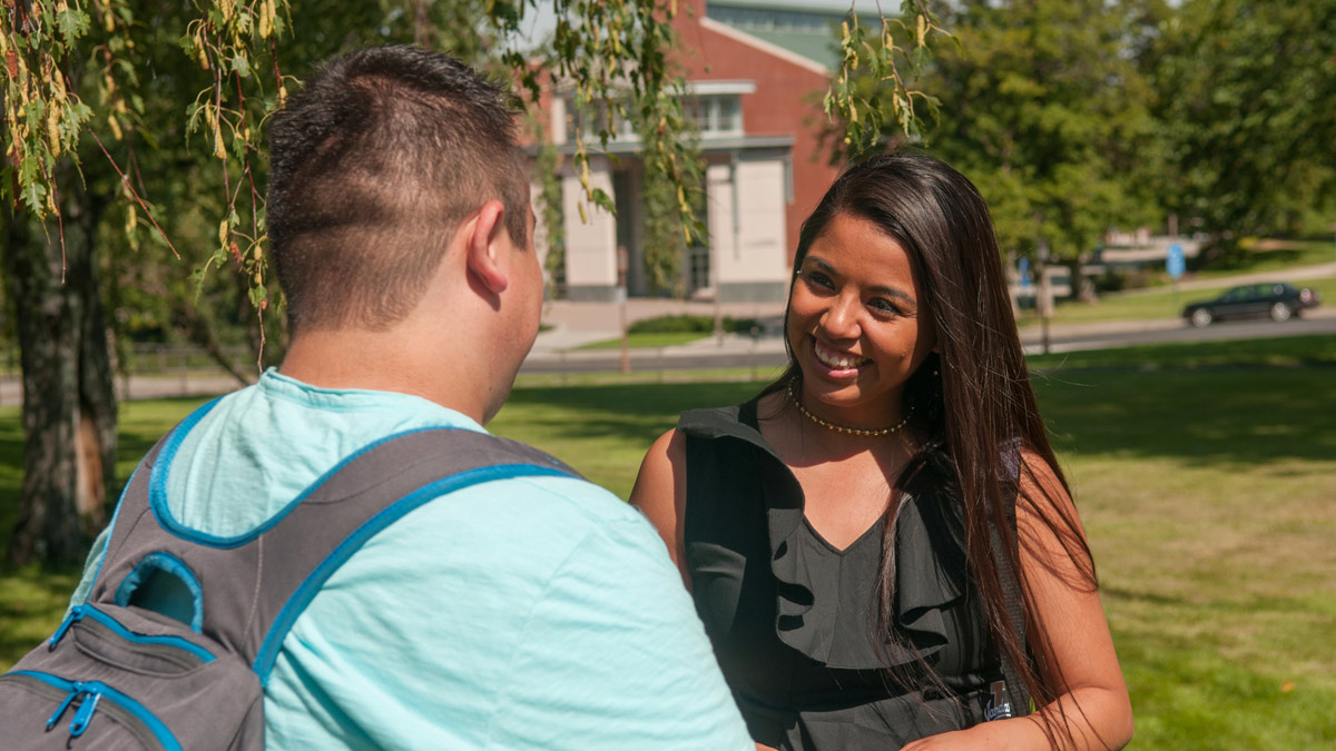 Two students talk on the Admin Lawn.