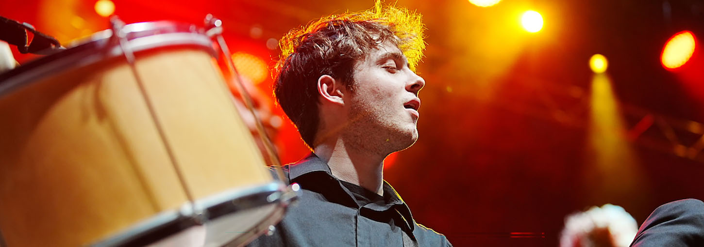 Closeup of performer playing drums on stage