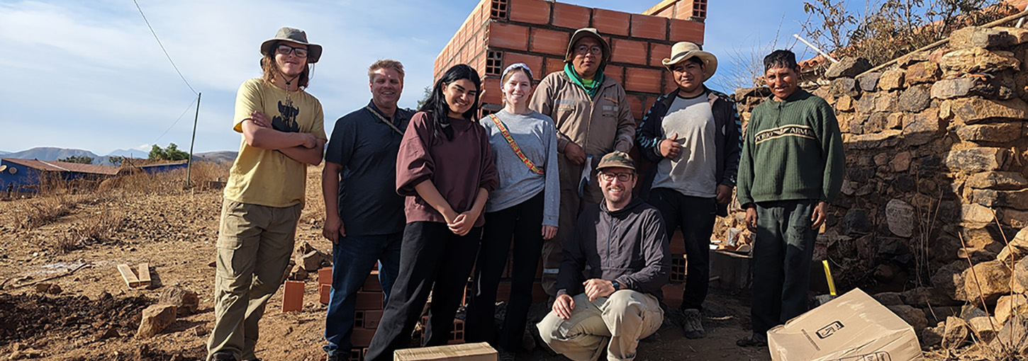 Students stand with recently built latrine