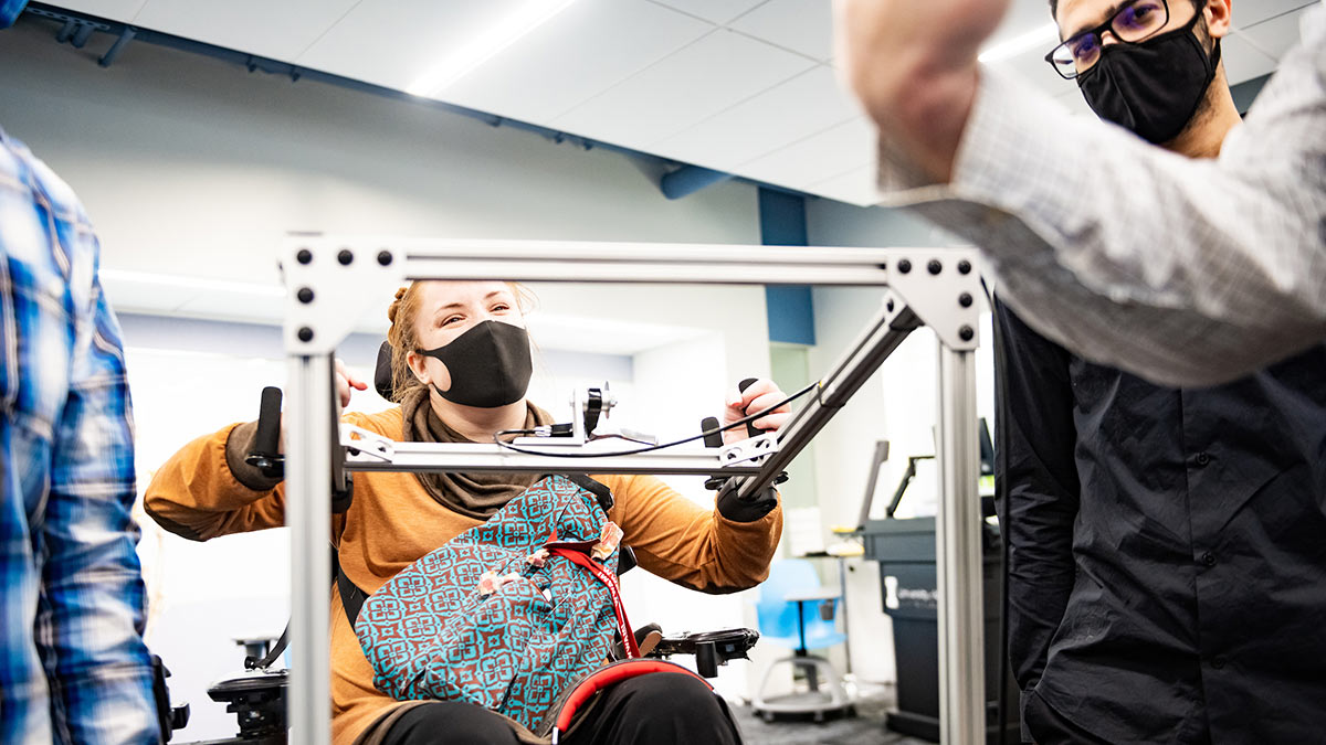 A WWAMI Medical Education Program student, who uses a wheelchair, test the assistive CPR device developed by College of Engineering students.