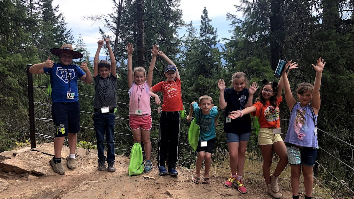 Several children pose on a hiking trail.