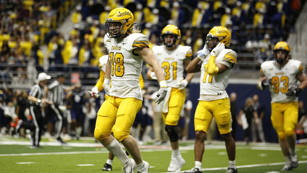 Five football players in white and gold uniforms.