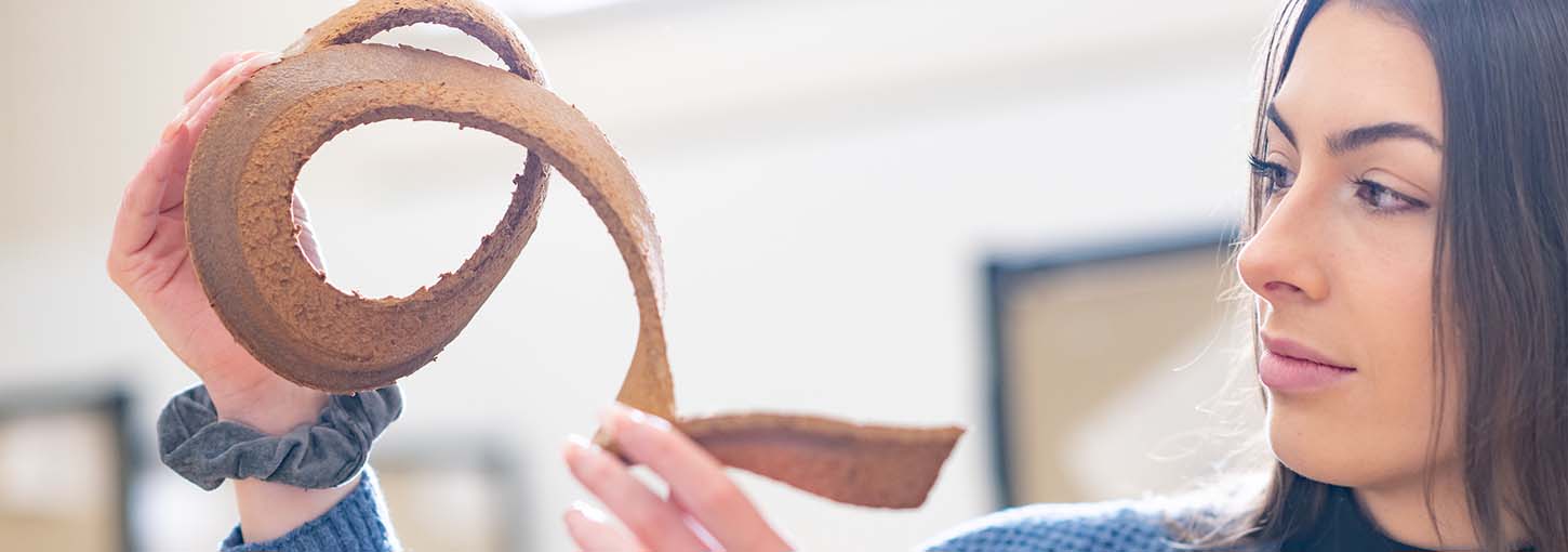 Marissa Hilliard examines a sample of 3D printed wood waste