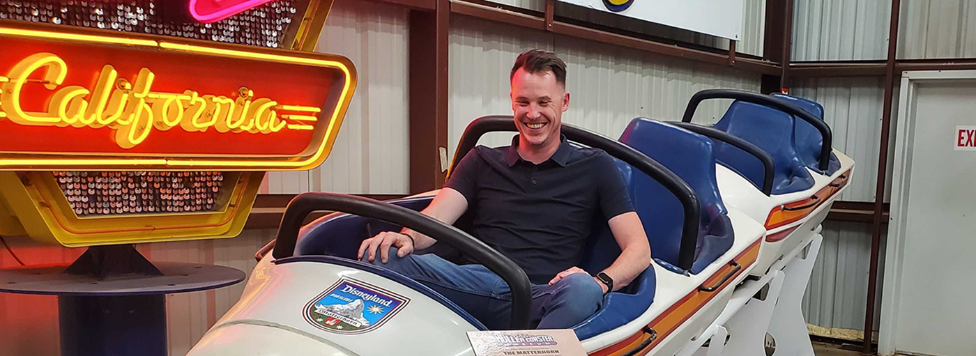 Man sits in old Matterhorn roller coaster train car.