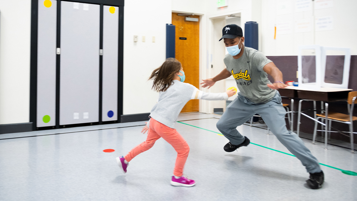 Vandal defensive back Wyryor Noil plays a game with a young girl in a Lena