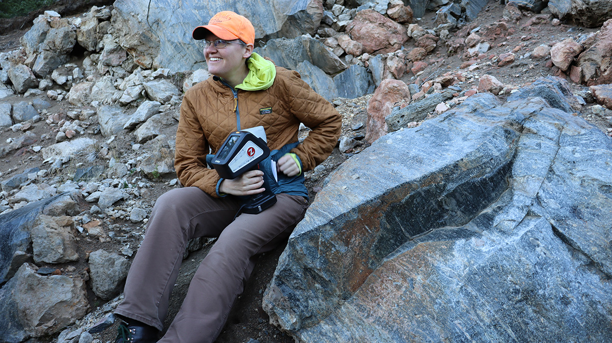 Erika Rader sits on a pile of rocks at Crater Lake, Oregon.